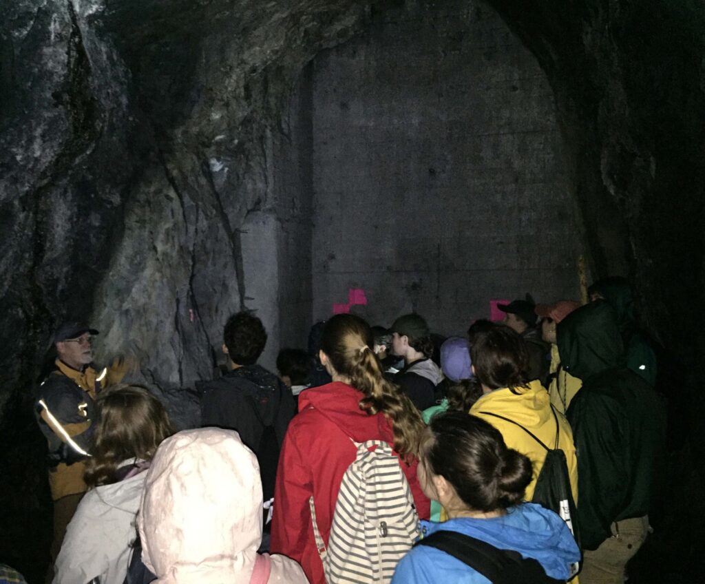 Bob Dumbrowe (left, with the glowing jacket) discusses with students the great concrete wafer blocking the tunnel.
